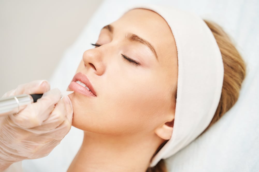 Permanent lip color treatment being applied to the lips.