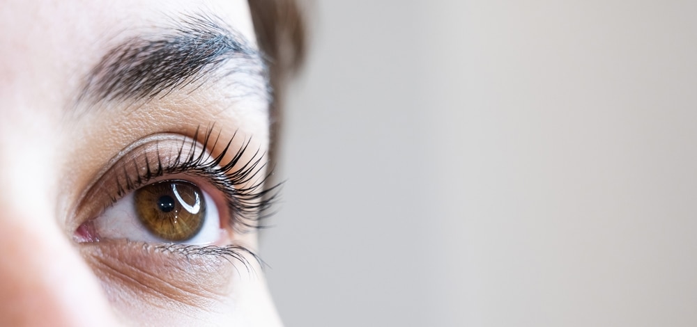 Woman receiving a lash extension fill.